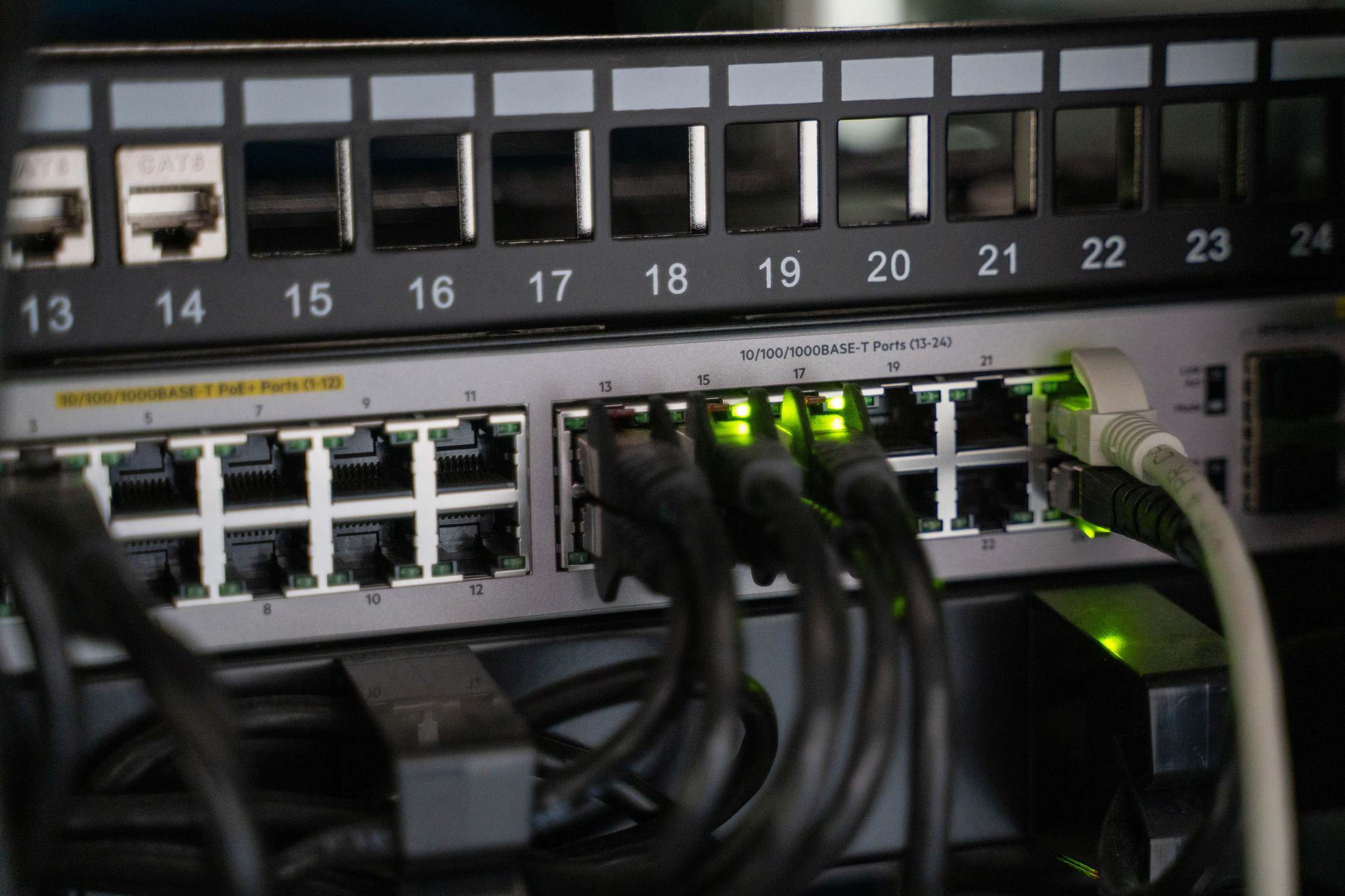 Server racks in a data center at night, networking equipment with connected cables